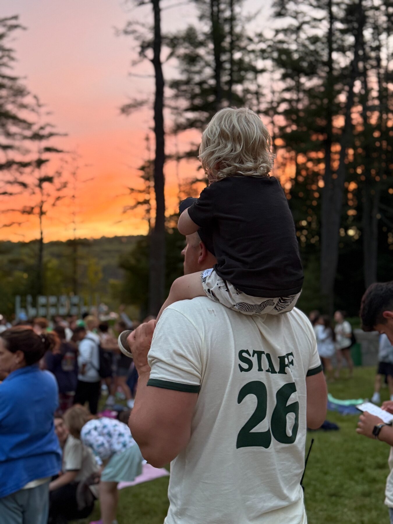 A family moment photographed from behind at summer camp